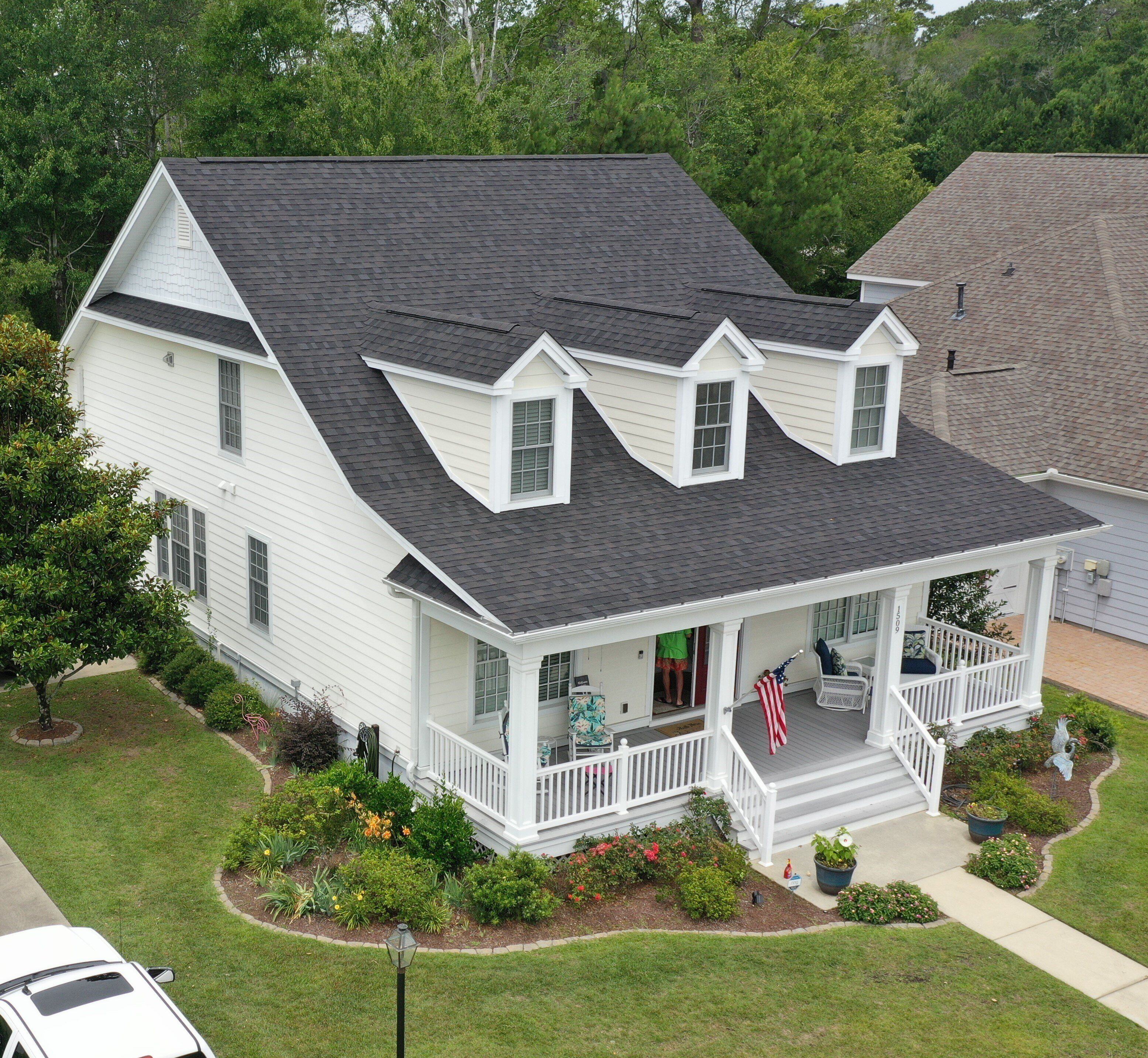 A dark gray roof on a white house completed by Linta Roofing