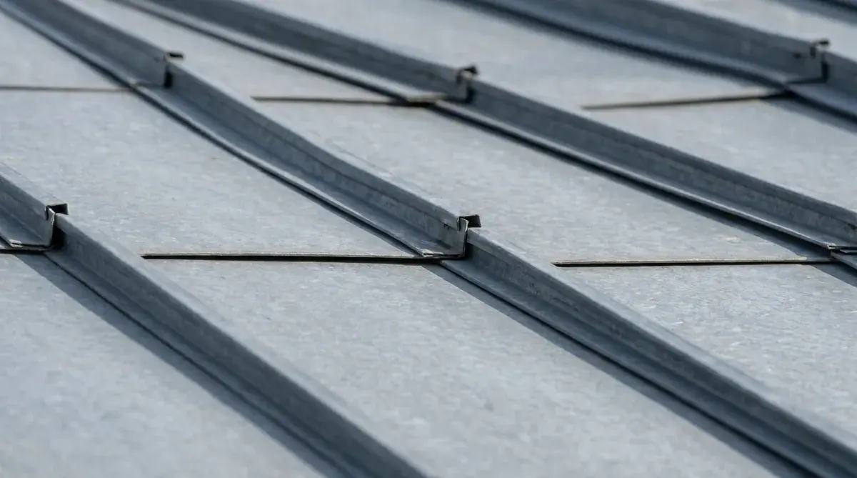 Close up view of standing seam metal roof showing raised vertical seams and smooth panels