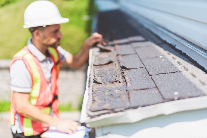 Roofer purposefully ripping up shingles