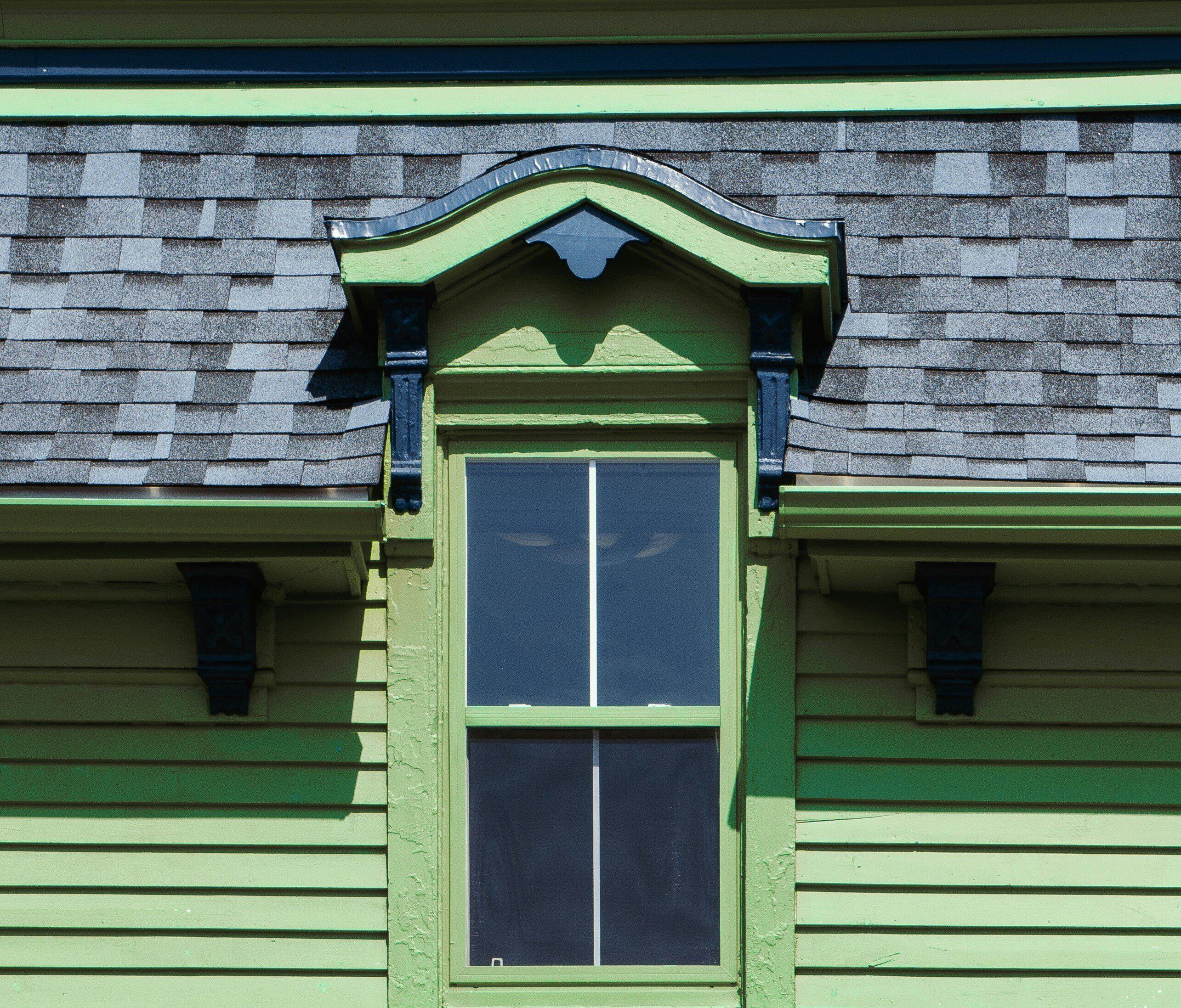 House with green siding and a gray roof